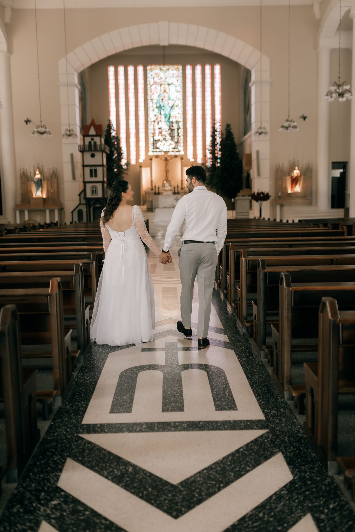 Pasangan pengantin berjalan di dalam gereja