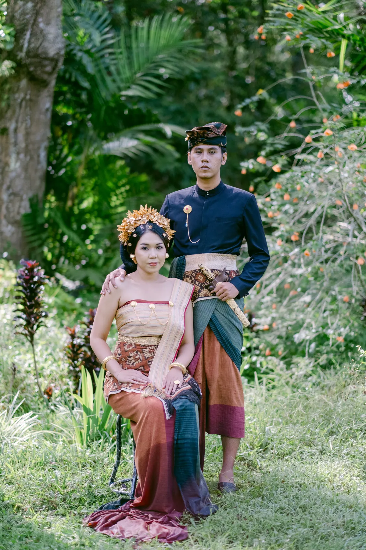 Pasangan pengantin dalam busana adat Bali di taman