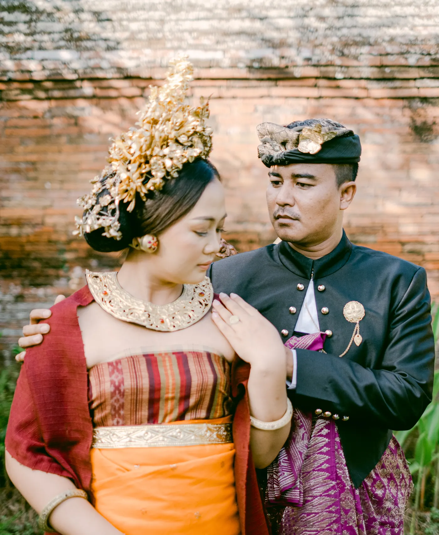 Pasangan saling memandang di depan dinding bata