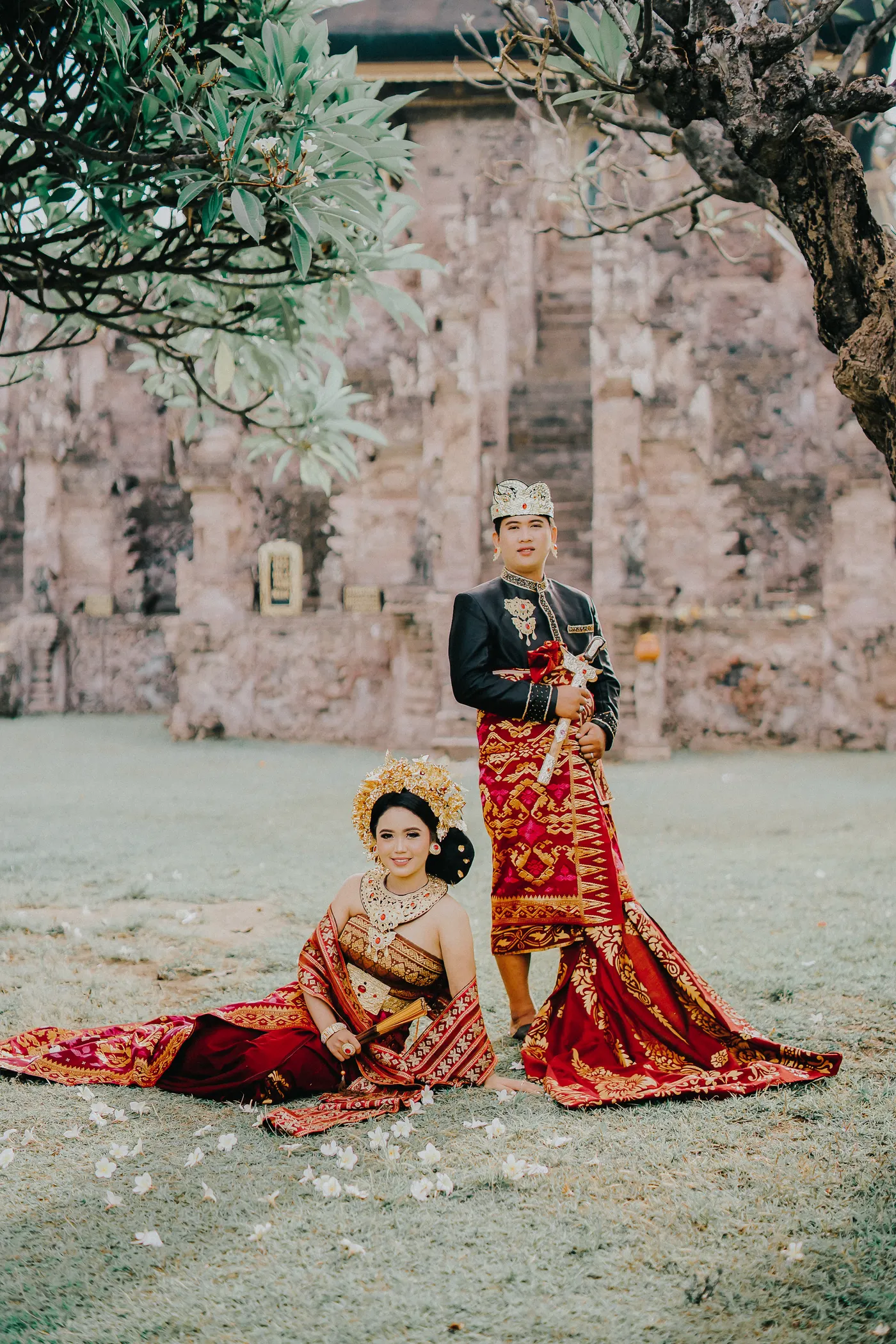 Pasangan dalam busana merah di taman